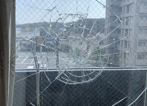 衝撃により割れた窓ガラス